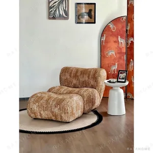 Lazy Curved Lounge Chair with Ottoman in Amber Bouclé — in a room setting
