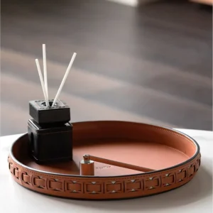 Round Black Leather Entryway Tray with Studded Rim in black — in a room setting