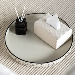 Round Black Leather Entryway Tray with Studded Rim in black — in a room setting