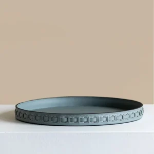 Round Black Leather Entryway Tray with Studded Rim in black — in a room setting