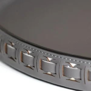 Round Black Leather Entryway Tray with Studded Rim in black — in a room setting