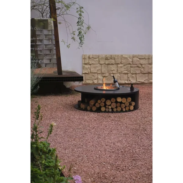 Round Outdoor Wood-Burning Fire Pit in black — in a room setting