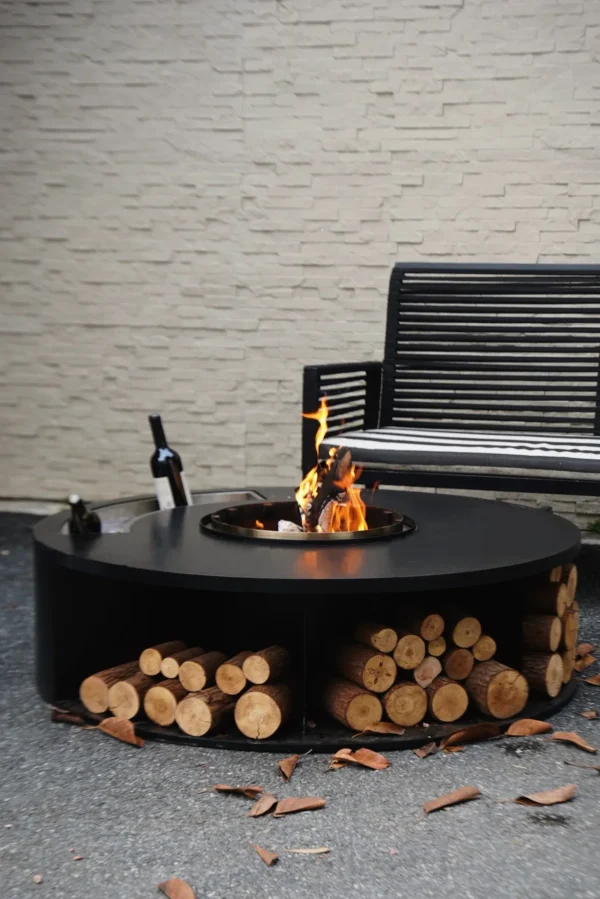 Round Outdoor Wood-Burning Fire Pit in black — in a room setting