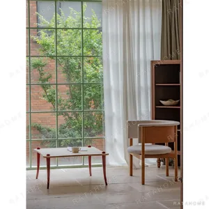 Luoli Curved Wood Coffee Table with Red Splayed Legs in natural oak — in a room setting