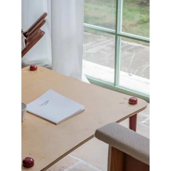 Luoli Curved Wood Coffee Table with Red Splayed Legs in natural oak — in a room setting