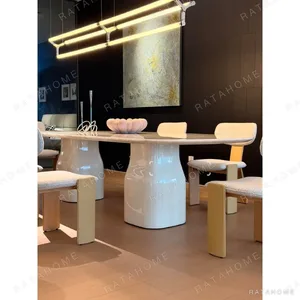 Rounded Rectangular Marble Dining Table on Pedestal Base in oatmeal — in a room setting