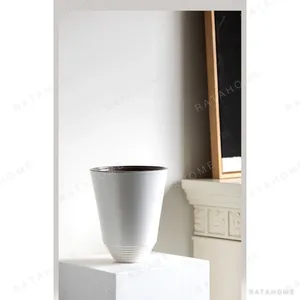 Matte White Cone Ceramic Vase with Spiral-Ribbed Base in ivory — in a room setting