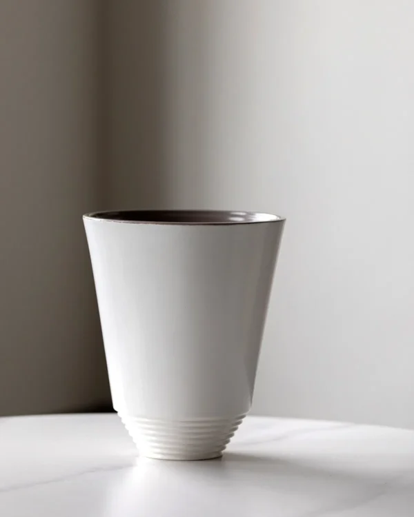 Matte White Cone Ceramic Vase with Spiral-Ribbed Base in ivory — in a room setting