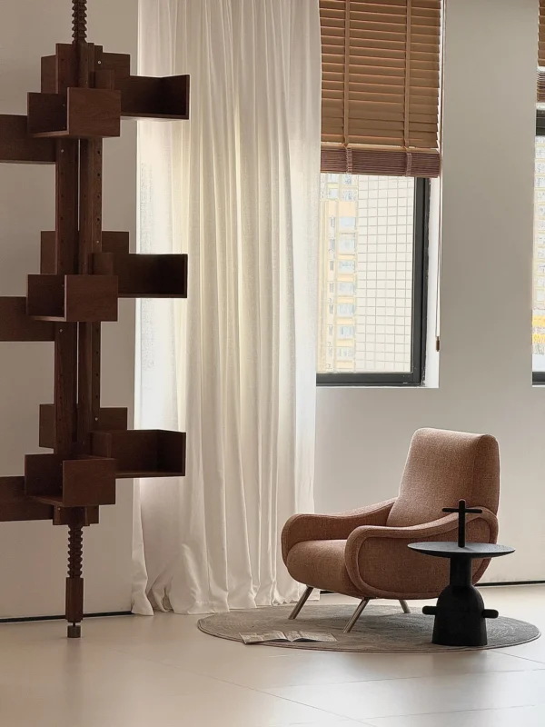 Curved Blush Fabric Lounge Chair on Slim Metal Legs in rose stone — in a room setting