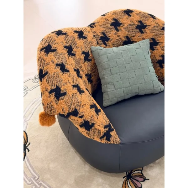 Mid-Century Houndstooth and Leather Round Lounge Chair in black — in a room setting