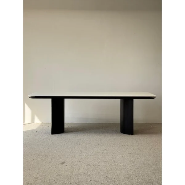 Long White Crystal Marble Dining Table on Curved Black Base in ivory — in a room setting