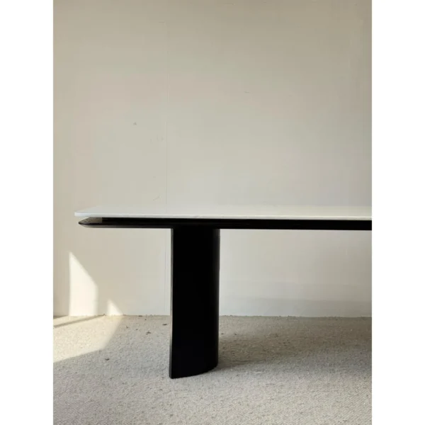 Long White Crystal Marble Dining Table on Curved Black Base in ivory — in a room setting