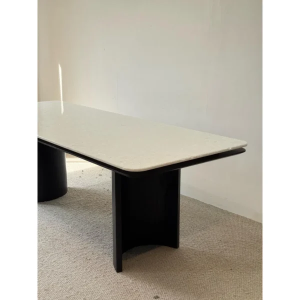 Long White Crystal Marble Dining Table on Curved Black Base in ivory — in a room setting