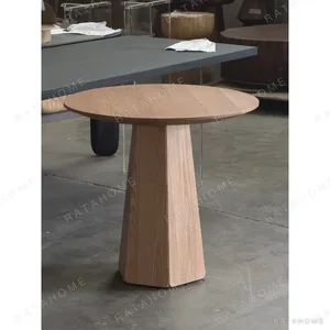 Minimalist Solid Wood Round Table on Faceted Cone in natural oak — in a room setting