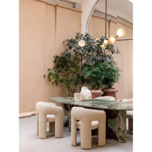 Monet Forest Stone Oval Dining Table on Sculpted Base in olive — in a room setting