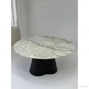 Movement Round Marble Table on Wave-Layered Black Base in ivory — in a room setting