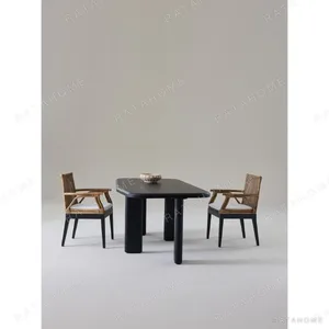 Moyu Black Dining Table with Cane Armchairs in black — in a room setting