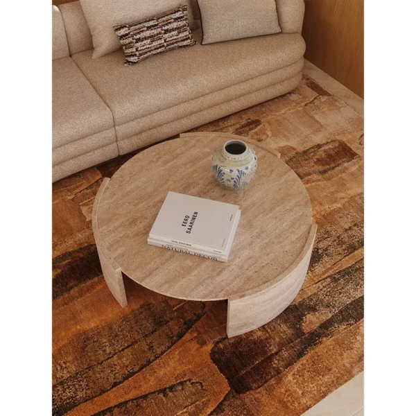 Round Natural Travertine Coffee Table on Three-Arc Ring Base in sand — in a room setting