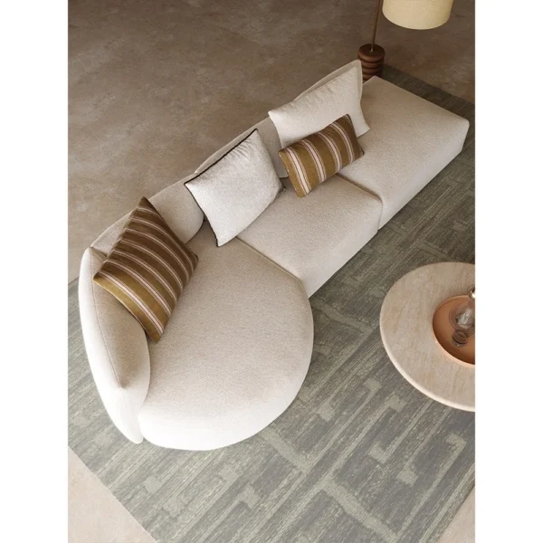 Naturalist Curved Modular Sofa in sand — in a room setting