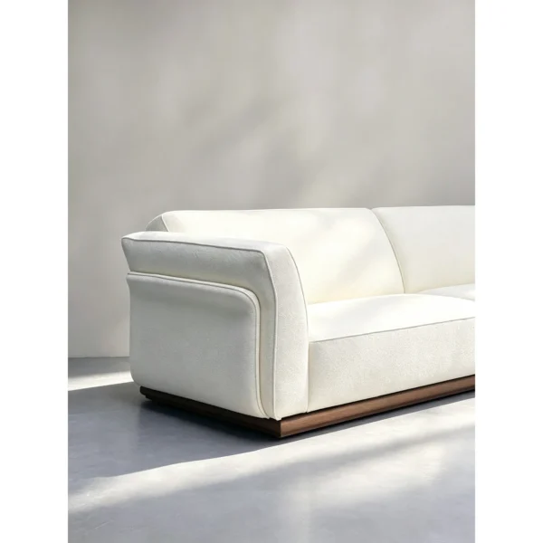 Negative Space Corner Sofa in Cream Fabric on Walnut Plinth — in a room setting