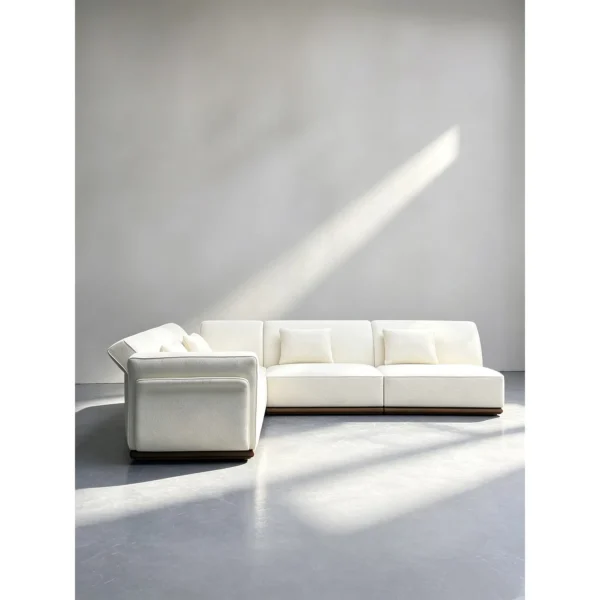 Negative Space Corner Sofa in Cream Fabric on Walnut Plinth — in a room setting
