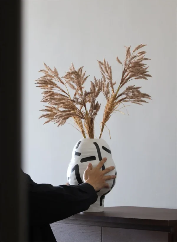 White Ceramic Lantern Vase with Black Lines, Medium in ivory — in a room setting