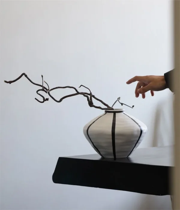 White Ceramic Lantern Vase with Black Lines, Medium in ivory — in a room setting