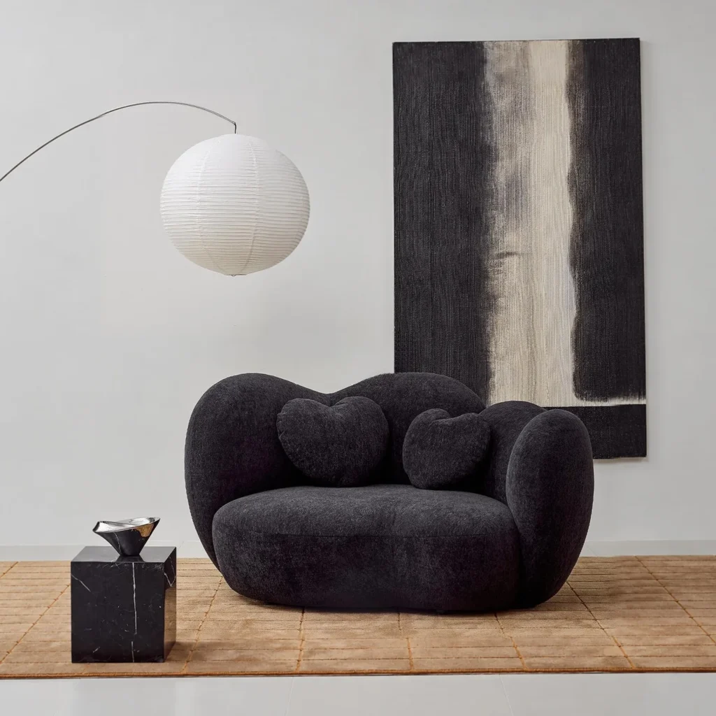 Nian Black Bouclé Curved Armchair with Heart Cushion in black — front view