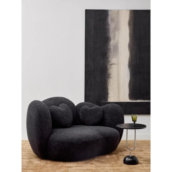 Nian Black Bouclé Curved Armchair with Heart Cushion in black — in a room setting