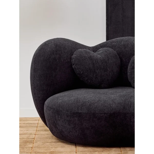 Nian Black Bouclé Curved Armchair with Heart Cushion in black — in a room setting