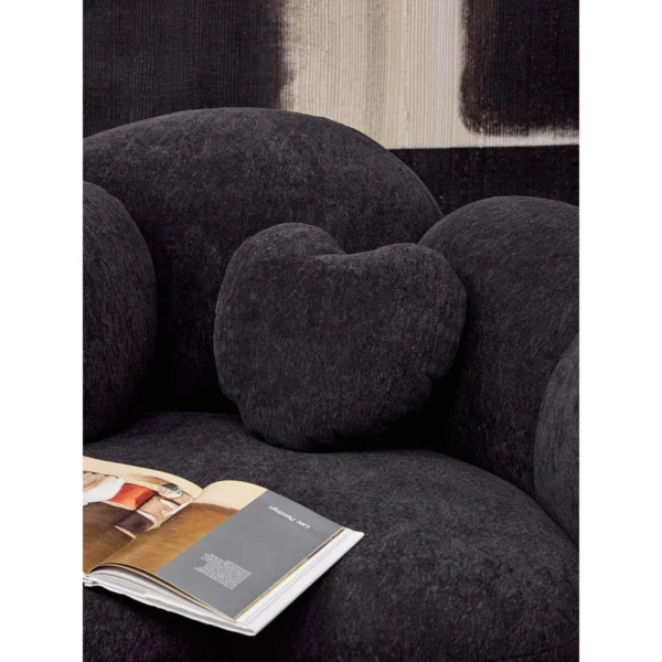 Nian Black Bouclé Curved Armchair with Heart Cushion in black — in a room setting