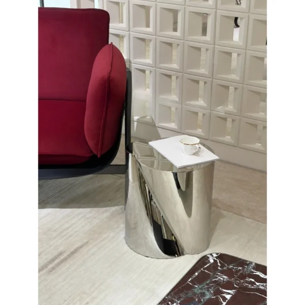 Twisted Cylinder Mirror Steel Side Table in silver — in a room setting