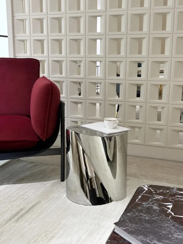 Twisted Cylinder Mirror Steel Side Table in silver — in a room setting