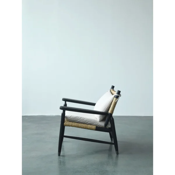 Black Oak Lounge Chair with Rattan Seat and Down Cushion in black — in a room setting