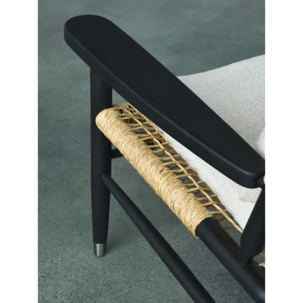Black Oak Lounge Chair with Rattan Seat and Down Cushion in black — in a room setting