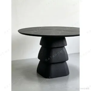 Black Oak Round Table on Stacked Sculptural Pedestal in black — in a room setting
