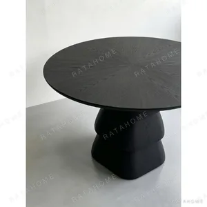 Black Oak Round Table on Stacked Sculptural Pedestal in black — in a room setting