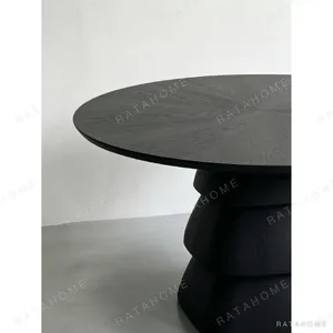 Black Oak Round Table on Stacked Sculptural Pedestal in black — in a room setting