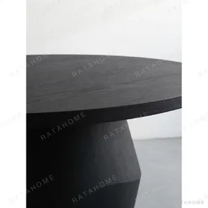 Matte Black Oak Round Dining Table on Faceted Pedestal in black — in a room setting