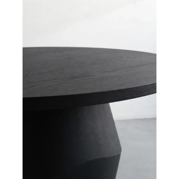 Matte Black Oak Round Dining Table on Faceted Pedestal in black — in a room setting