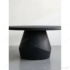 Matte Black Oak Round Dining Table on Faceted Pedestal in black — in a room setting