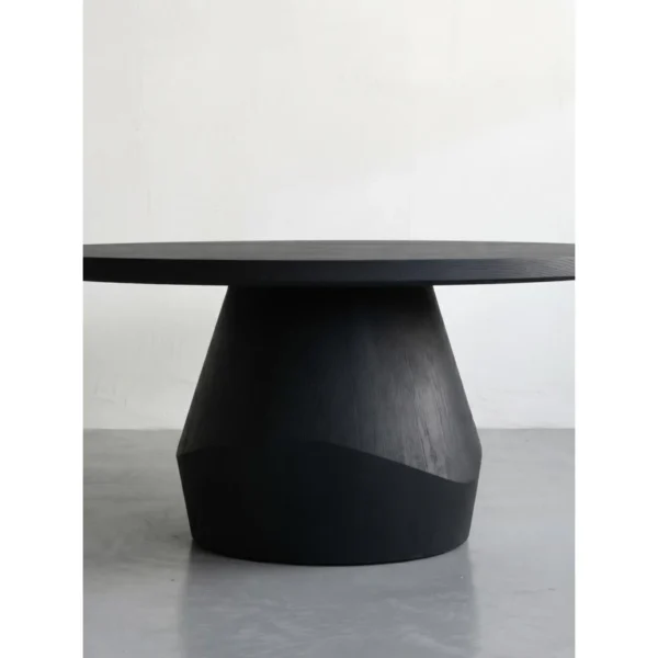 Matte Black Oak Round Dining Table on Faceted Pedestal in black — in a room setting