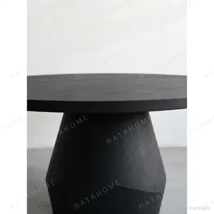 Matte Black Oak Round Dining Table on Faceted Pedestal in black — in a room setting