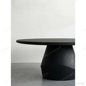 Matte Black Oak Round Dining Table on Faceted Pedestal in black — in a room setting