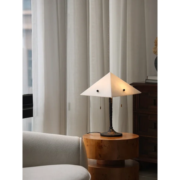 Faux Alabaster Pyramid Table Lamp with Antique Brass Base in ivory — in a room setting