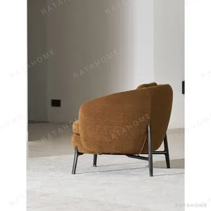 Curved Lounge Chair in Caramel Fabric on Slim Metal Legs — in a room setting