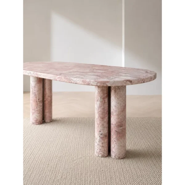 Pink-White Marble Oval Dining Table on Stone Cylinders in rose stone — in a room setting