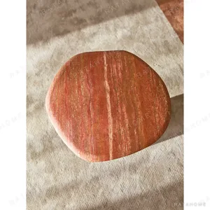 Red Travertine Pebble Side Table on Black Cylinder Base in red — in a room setting