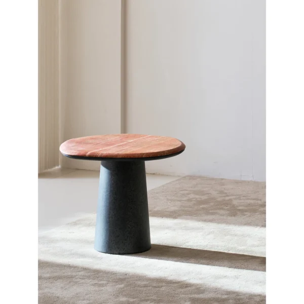 Red Travertine Pebble Side Table on Black Cylinder Base in red — in a room setting