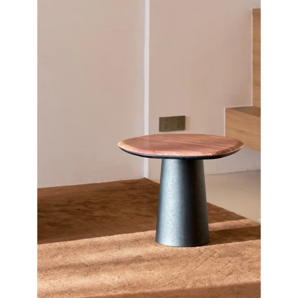 Red Travertine Pebble Side Table on Black Cylinder Base in red — in a room setting